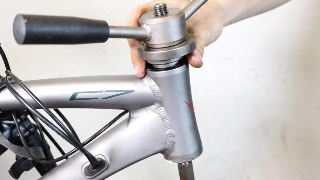 Placing a bike headset cup on the top of the head tube and fitting the headset press