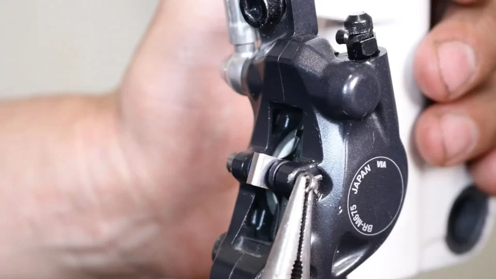 use long nose pliers to remove the small caliper spring clip